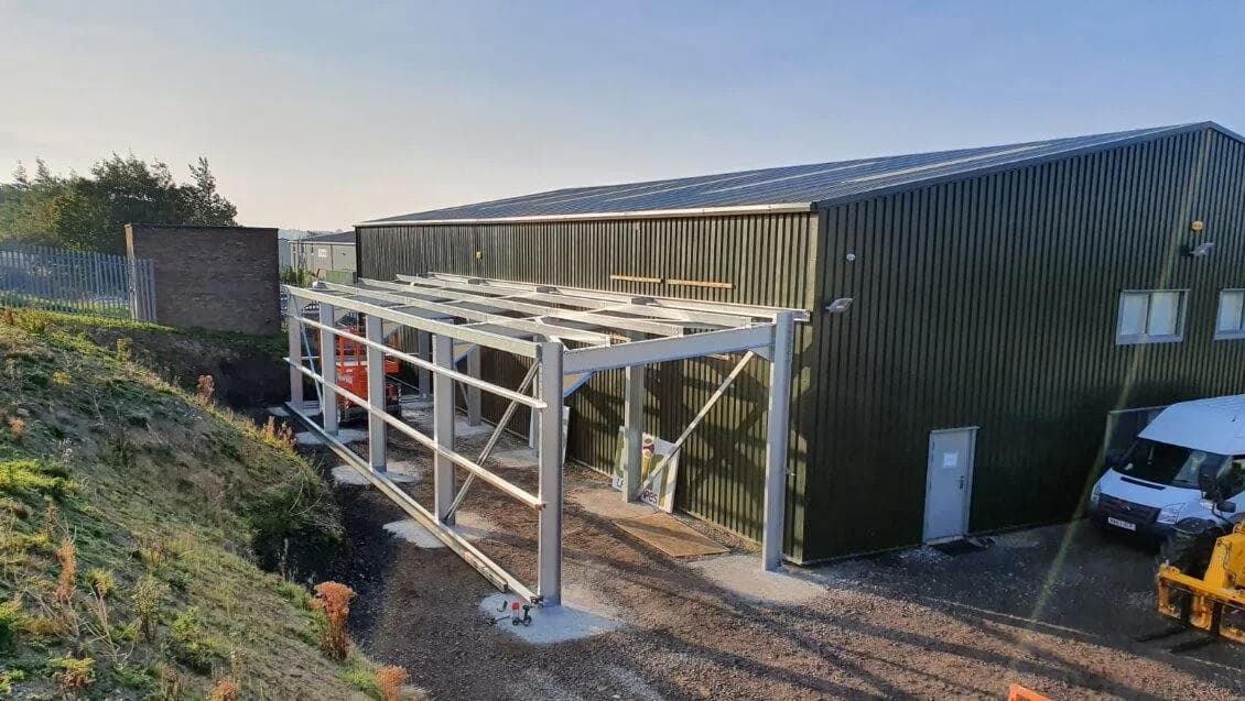 Galvanised steel frame for a warehouse extension going up on concrete pad foundations