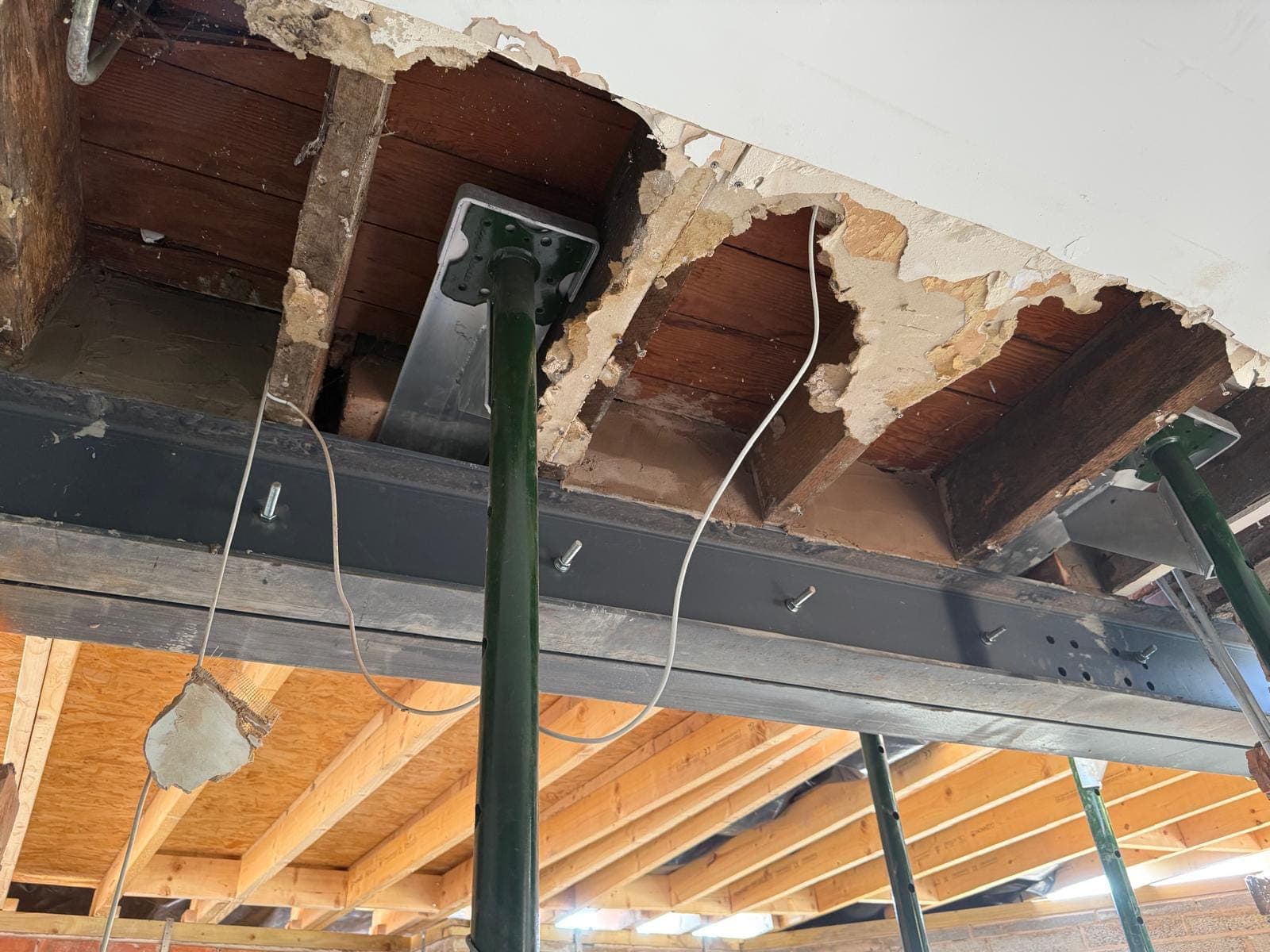 Steel beam set up within the floor zone with original joists one side and new extension joists the other