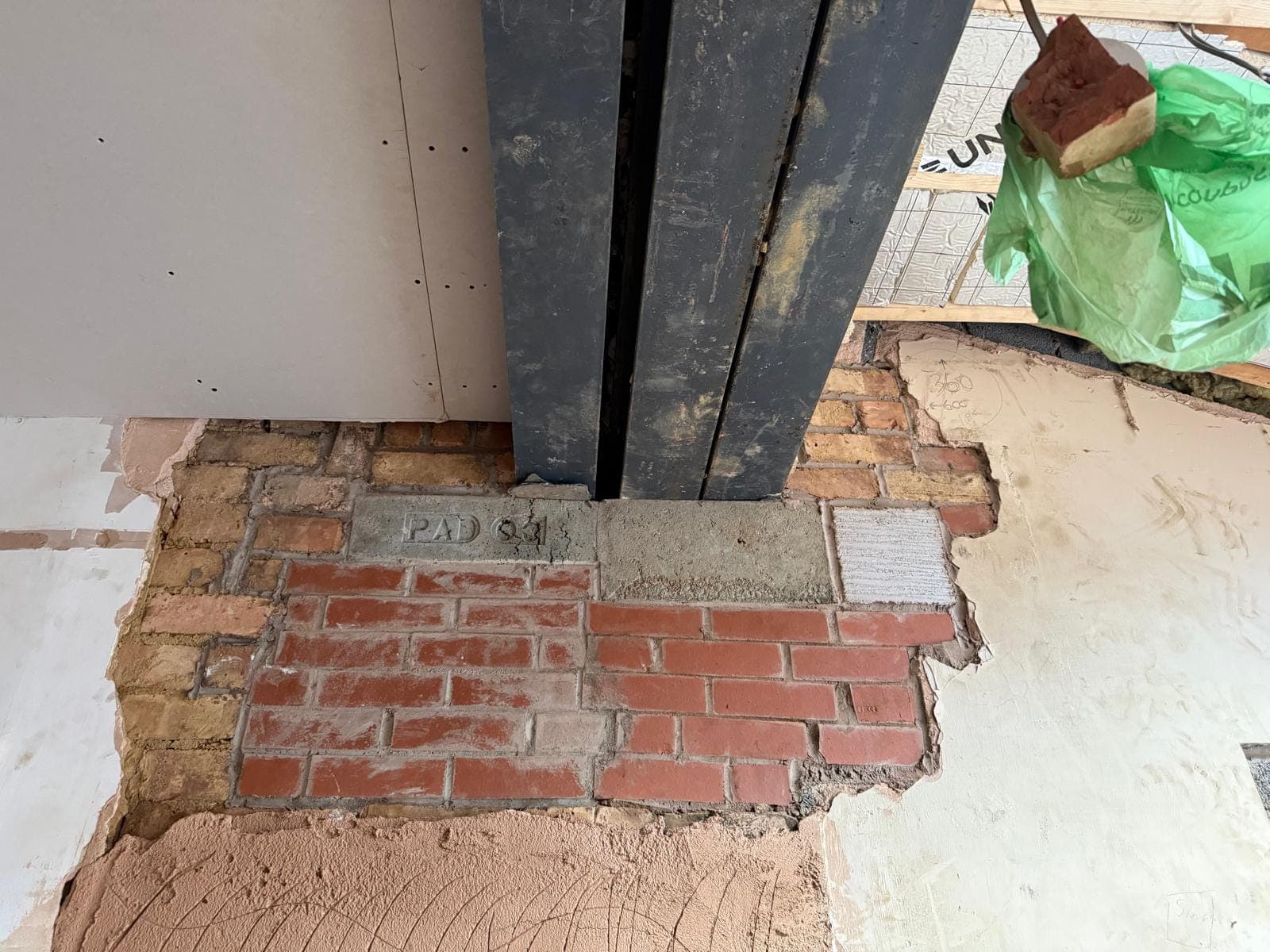 Twin steel beams bearing on a padstone with new matching brickwork built back underneath